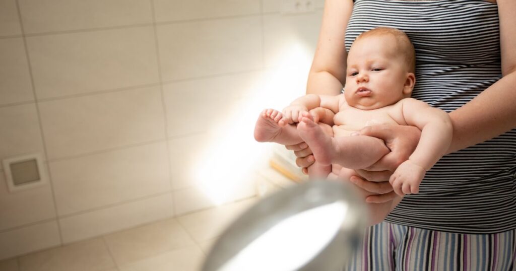 elimination-communication-mother-holding-her-baby-over-the-toilet