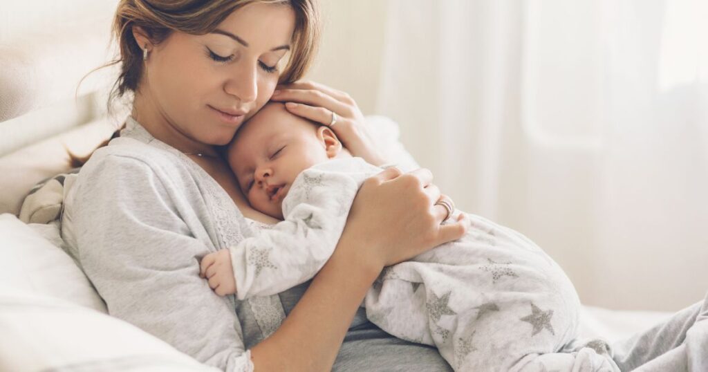 baby-sleep-mother-holding-sleeping-baby-close-to-her-chest-with-eyes-closed
