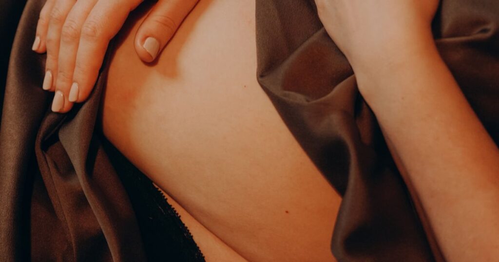 postpartum-bleeding-woman-holding-her-belly-while-laying-down