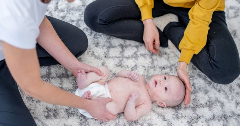 carrot-fertility-postpartum-doula-talking-to-mother-about-baby-while-baby-lays-on-mat