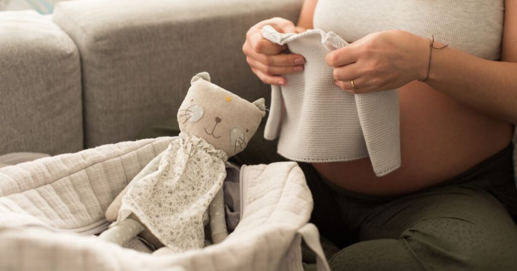 expecting-mother-packing-hospital-bag-with-baby-clothes