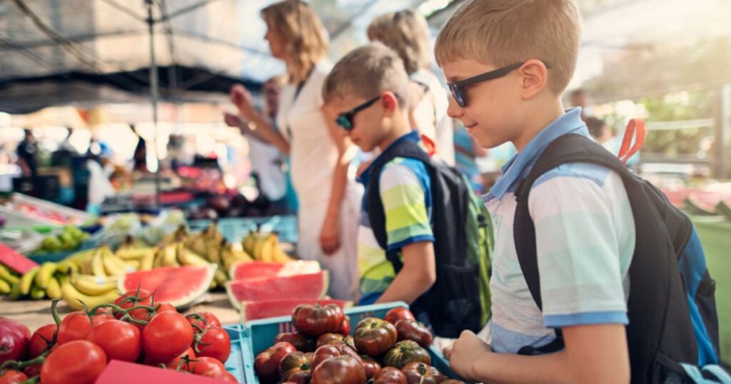 children-at-a-local-farmers-market-looking-at-vegetables