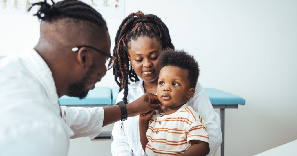 Charlotte-NC-pediatrician-Pediatrician-examining-a-young-child-while-the-mother-looks-on-during-a-doctors-visit