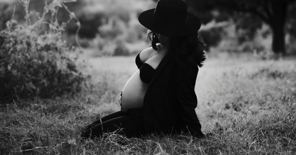 Artistic-black-and-white-maternity-portrait-of-pregnant-woman-sitting-outdoors-in-Charlotte-NC