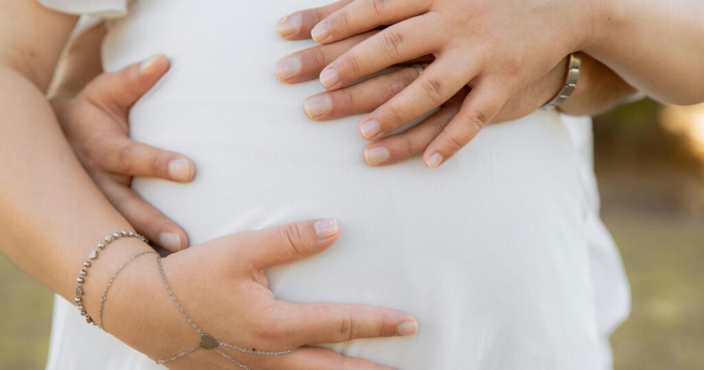 Expecting-parents’-hands-resting-on-baby-bump-during-maternity-photoshoot-in-Charlotte-NC