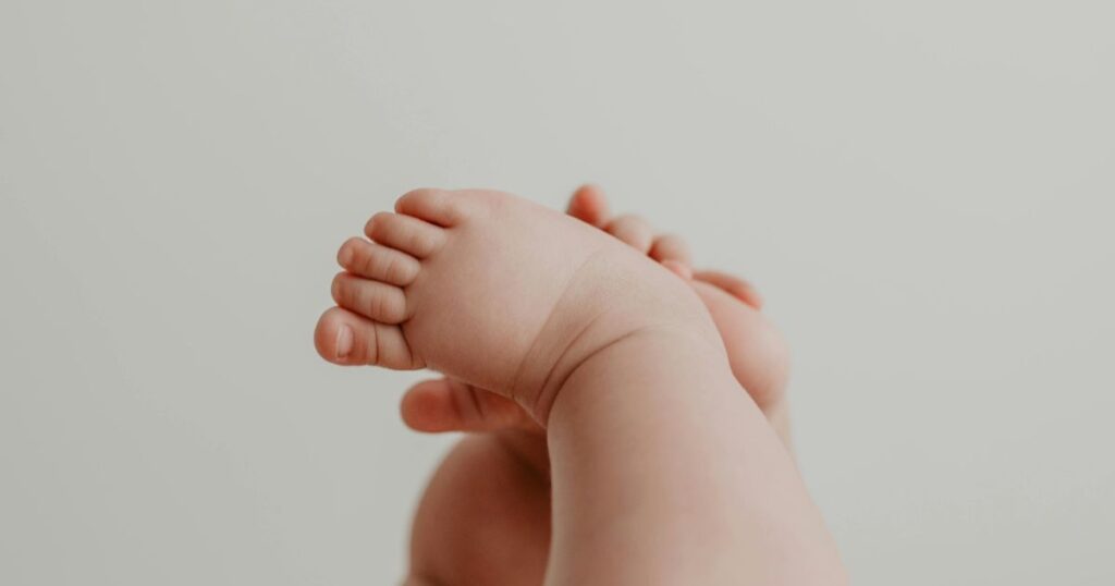 close up of newborn baby feet against a soft neutral background