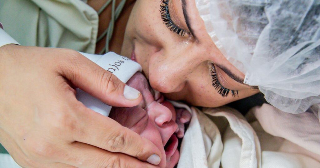 New mom kissing baby after hospital birth in charlotte, nc