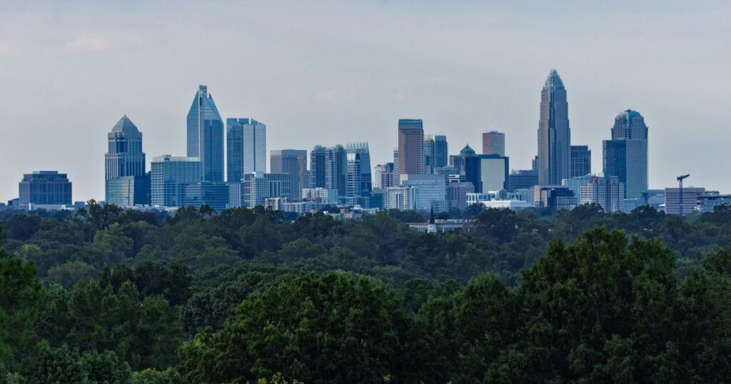 Charlotte skyline overlooking tree-lined neighborhoods in the Charlotte Metro area