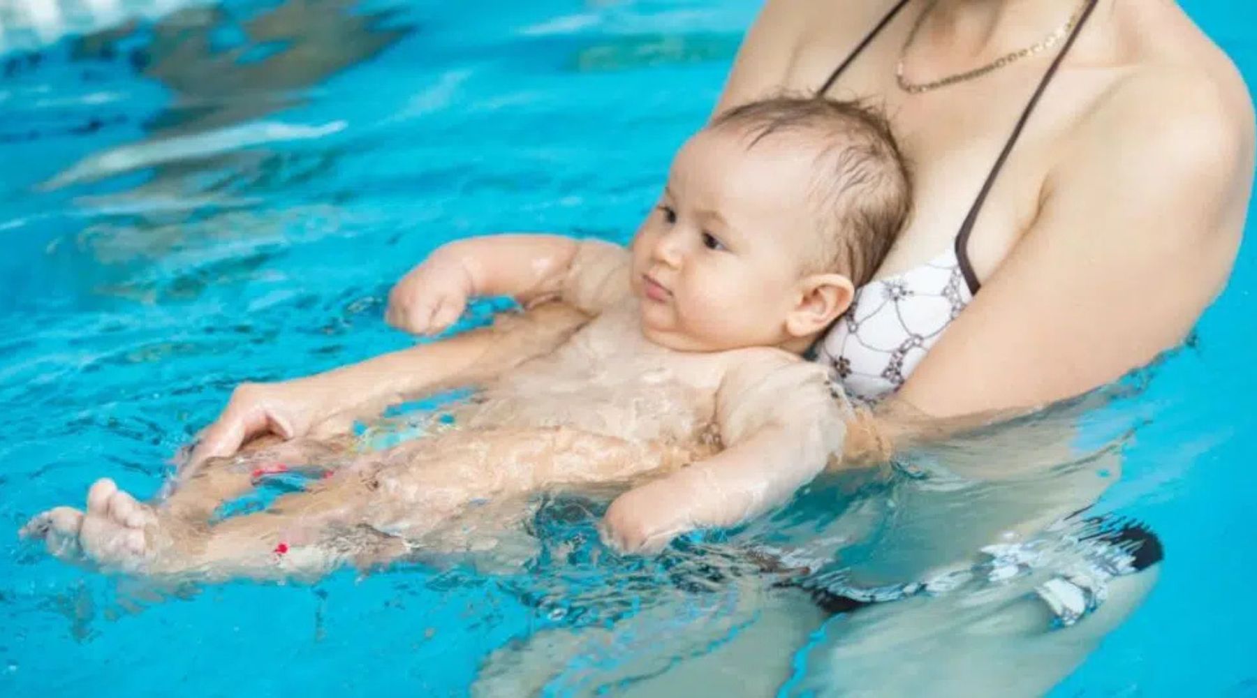 Baby swimming on the pool guided