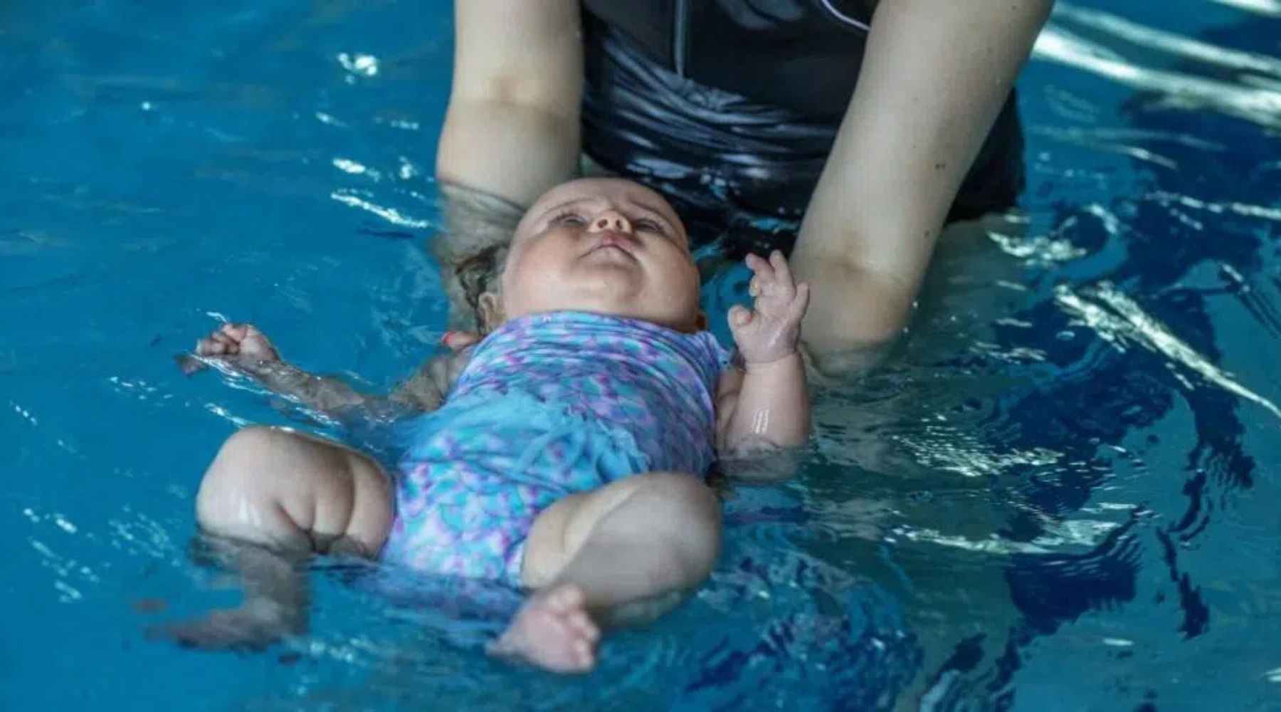Baby is doing back float guided
