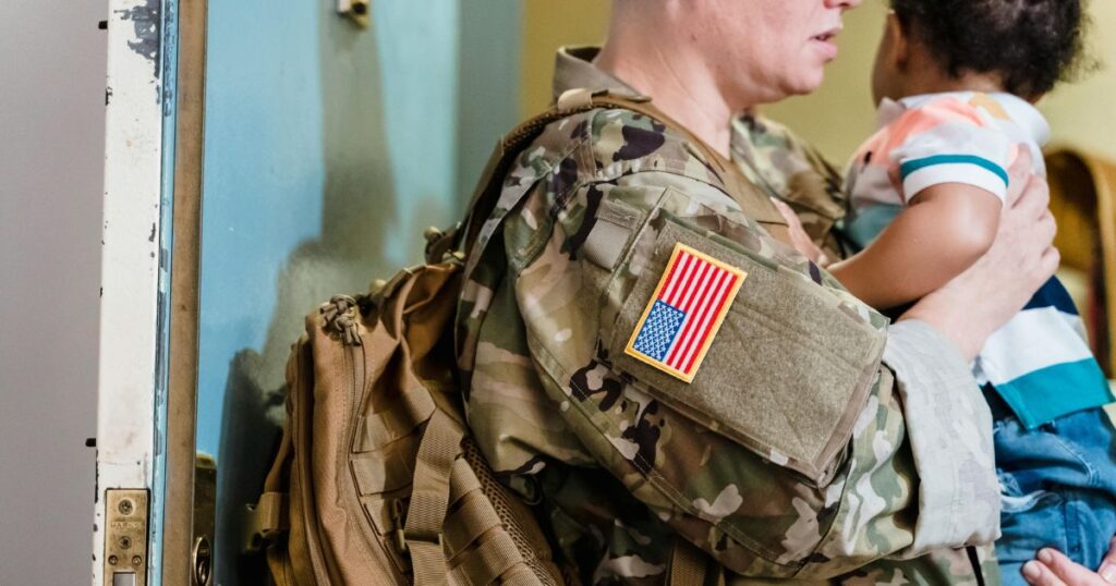 military mother wearing her uniform coming home to son and holding him