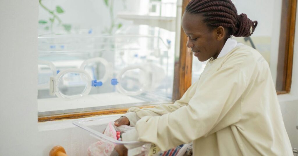 Newborn care beside a neonatal incubator in a hospital