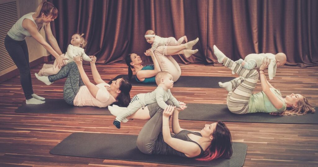 four moms and their babies participating in a mommy and me group class, guided by an instructor