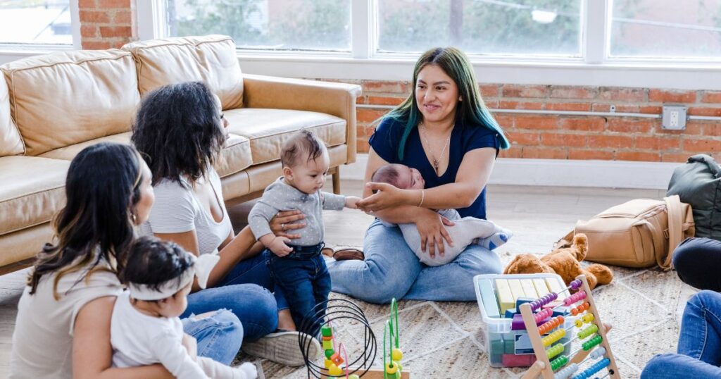 mom support group meetup with moms talking to each other while holding their babies