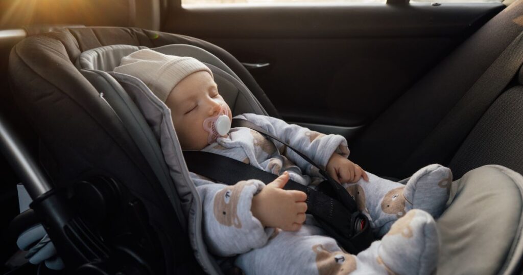 a baby who is sleeping while safely buckled into their car seat