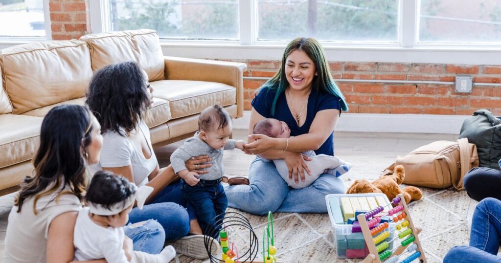 mothers and their babies in a mom group, smiling with and talking to each other